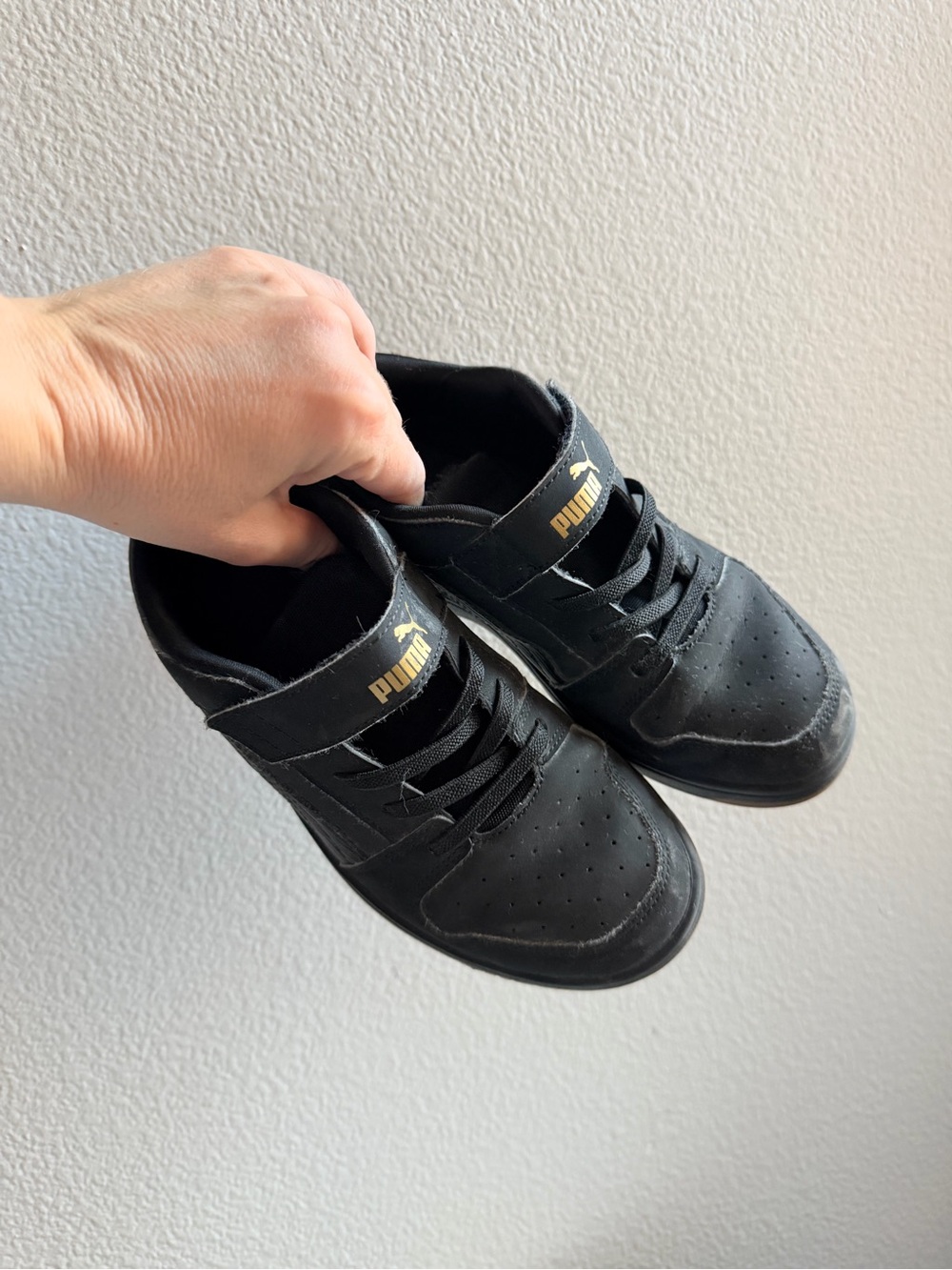 Kids PUMA Black Rebound Layup sneakers featuring a gold logo